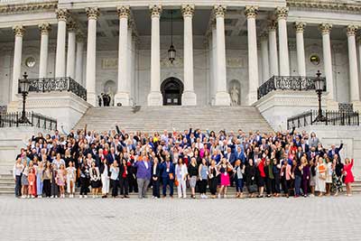 a large group of people stand on the steps of a building